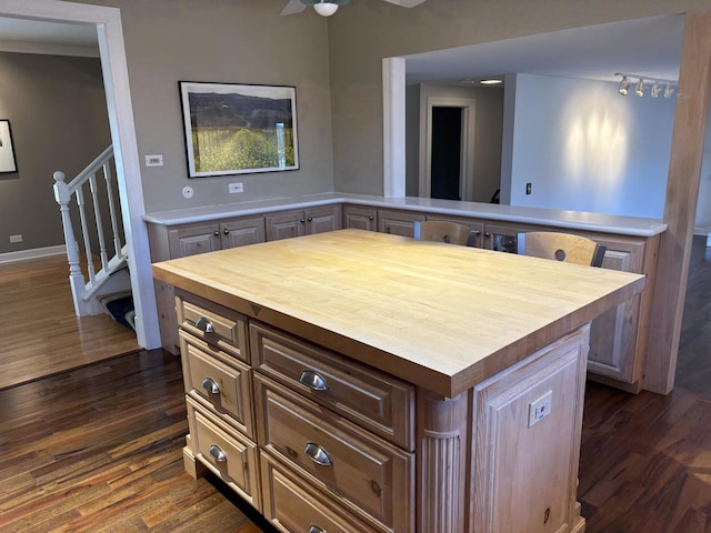 kitchen with kitchen peninsula, dark hardwood / wood-style floors, and a kitchen island