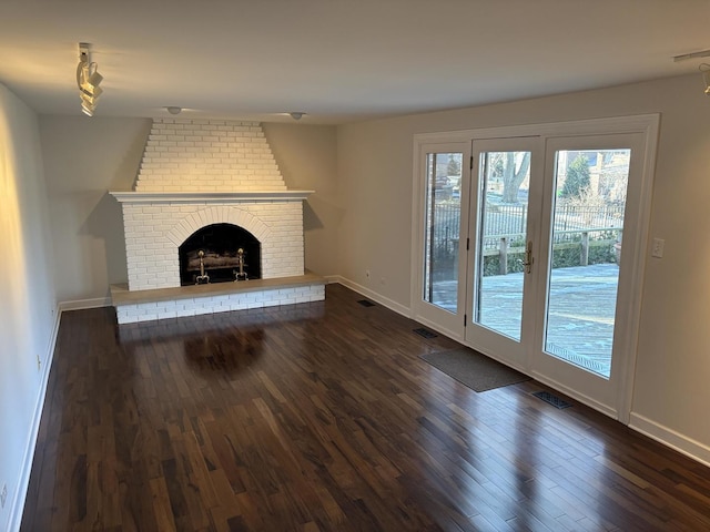 unfurnished living room featuring a fireplace and dark wood-type flooring