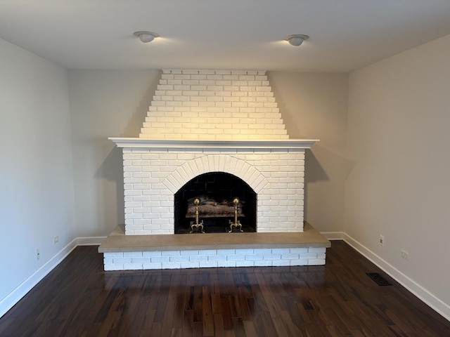 room details featuring wood-type flooring and a brick fireplace