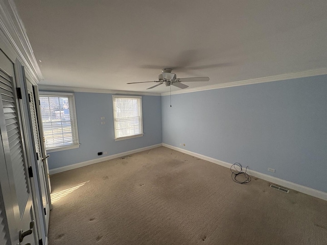 carpeted empty room with ceiling fan and ornamental molding