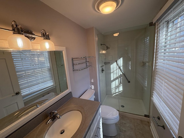 bathroom with vanity, toilet, tile patterned flooring, and walk in shower