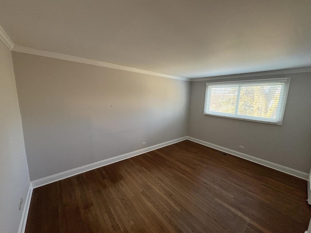 spare room featuring ornamental molding and dark wood-type flooring