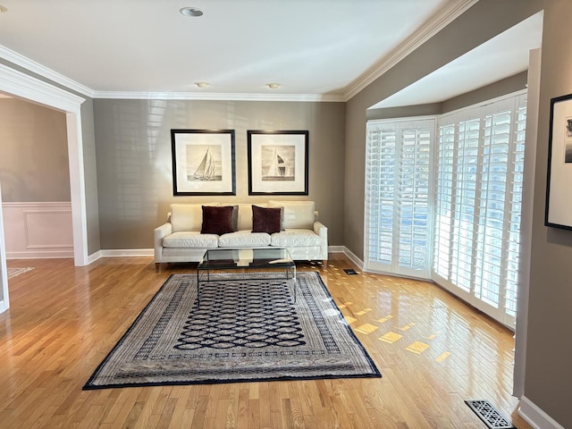 sitting room featuring light wood-type flooring and crown molding