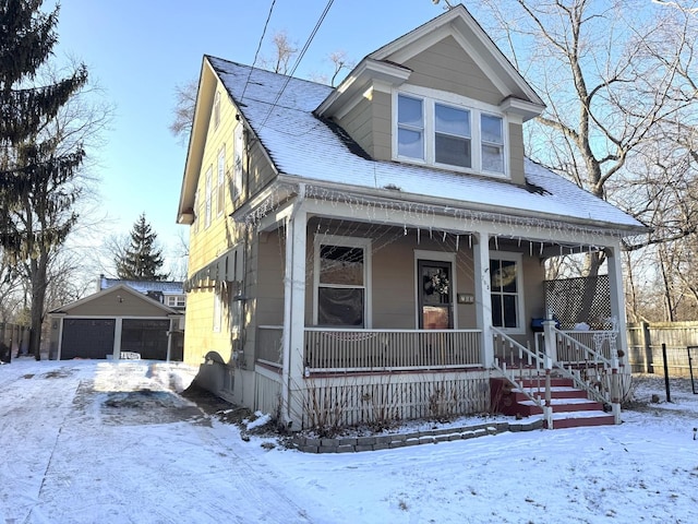 view of front facade featuring a garage, a porch, and an outbuilding