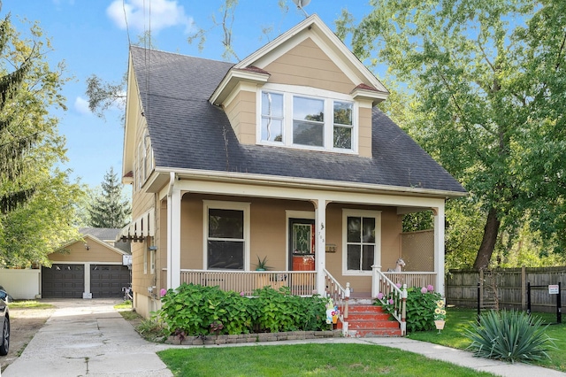 view of front of property with an outbuilding, covered porch, a front lawn, and a garage