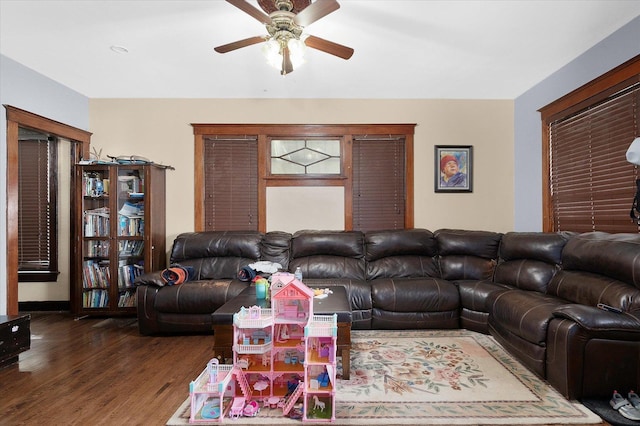 living room featuring ceiling fan and dark hardwood / wood-style floors