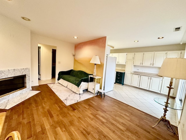 living room with light wood-type flooring and a fireplace