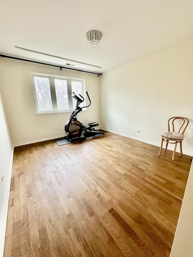 exercise room with hardwood / wood-style floors