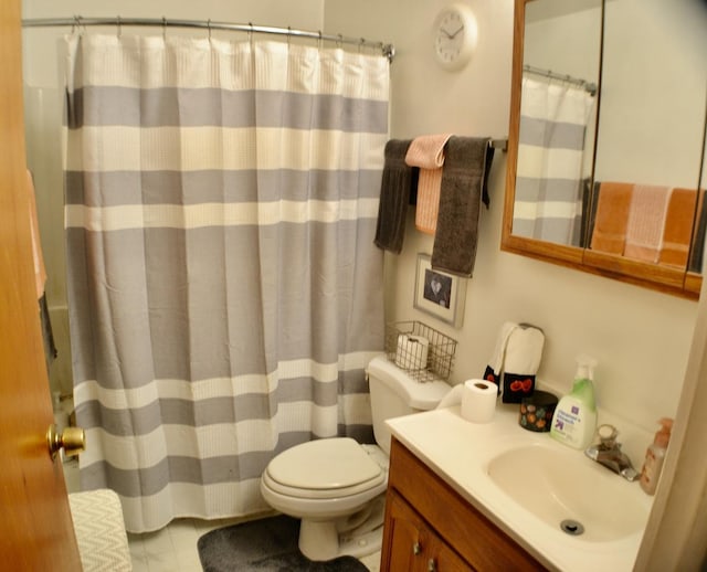 bathroom with tile patterned floors, vanity, toilet, and curtained shower