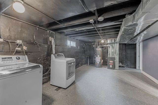 basement with heating unit, washer and dryer, and water heater