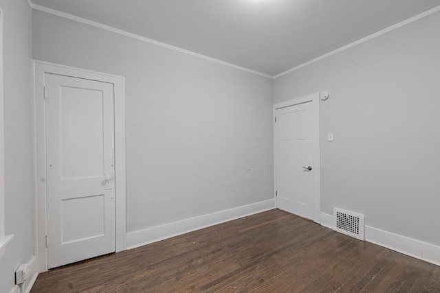 empty room featuring ornamental molding and dark wood-type flooring