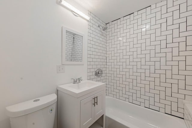 full bathroom featuring vanity, tiled shower / bath combo, and toilet