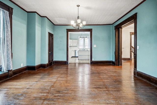 unfurnished room with hardwood / wood-style flooring, crown molding, sink, and an inviting chandelier