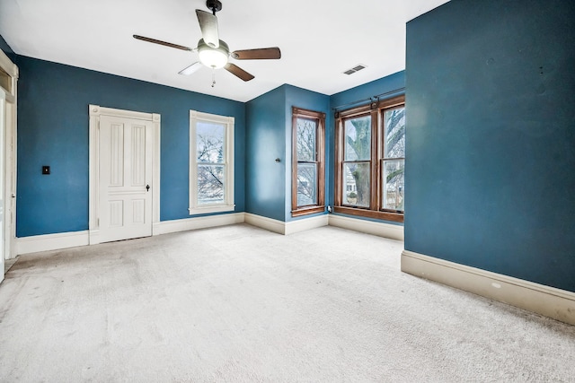 empty room featuring carpet flooring and ceiling fan