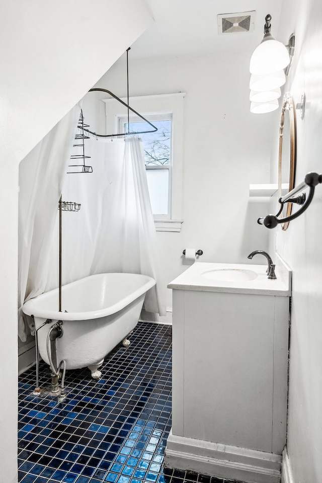 bathroom with vanity, tile patterned flooring, and a washtub