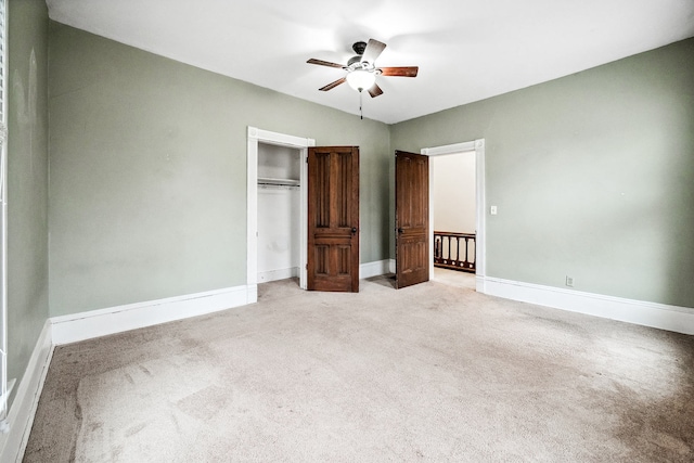 unfurnished bedroom featuring ceiling fan, a closet, and light carpet