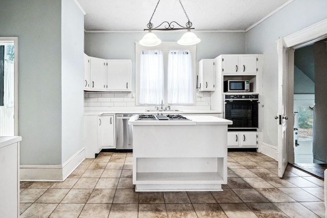 kitchen with appliances with stainless steel finishes, white cabinetry, hanging light fixtures, a kitchen island, and decorative backsplash