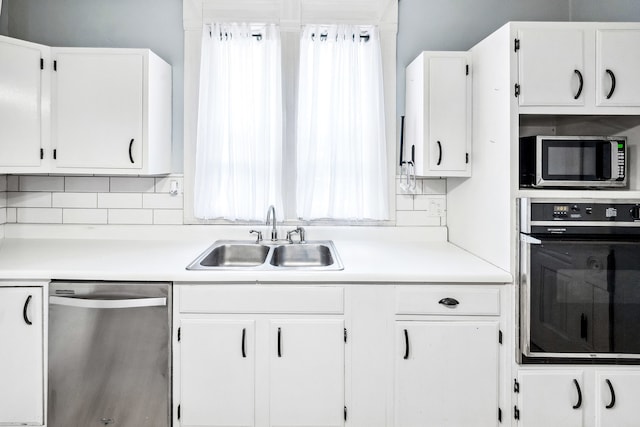 kitchen with white cabinetry, appliances with stainless steel finishes, sink, and decorative backsplash