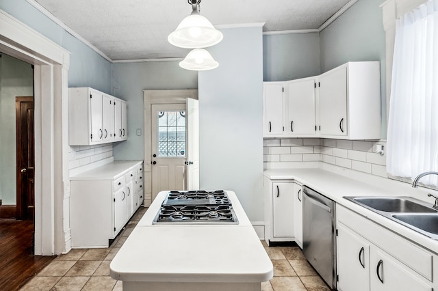 kitchen featuring pendant lighting, sink, crown molding, stainless steel appliances, and white cabinets