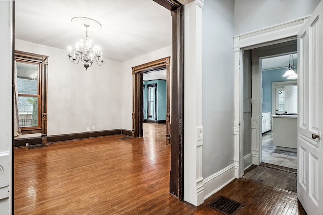 interior space featuring hardwood / wood-style flooring, a wealth of natural light, and a notable chandelier