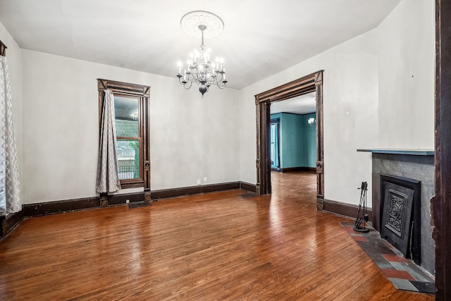 unfurnished dining area with hardwood / wood-style floors and a notable chandelier