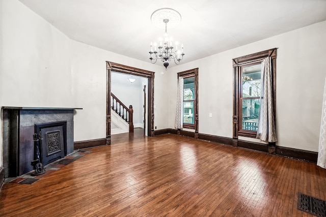 unfurnished living room featuring hardwood / wood-style flooring and a chandelier