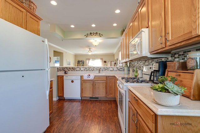 kitchen with white appliances, kitchen peninsula, ceiling fan, dark hardwood / wood-style flooring, and decorative backsplash