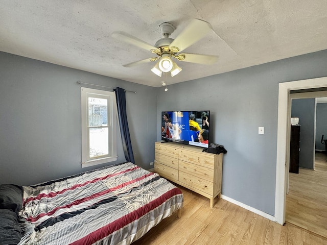 bedroom featuring wood-type flooring, a textured ceiling, and ceiling fan