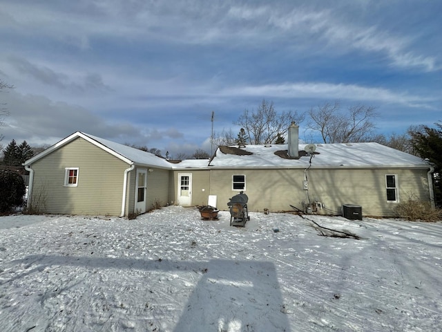 snow covered house with central air condition unit