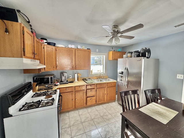 kitchen featuring ceiling fan, sink, light tile patterned floors, and stainless steel appliances