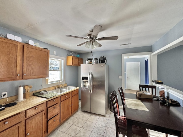 kitchen with ceiling fan, stainless steel fridge, light tile patterned flooring, and sink