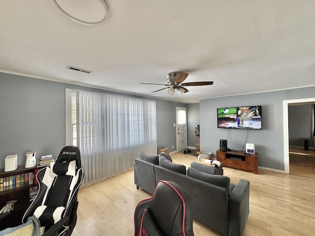 living room with light wood-type flooring, ceiling fan, and crown molding