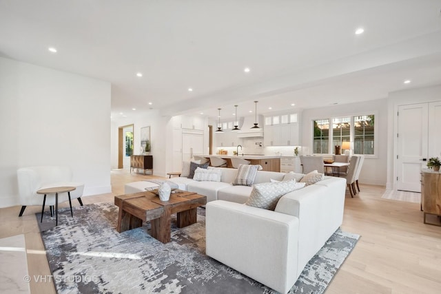 living room featuring sink and light hardwood / wood-style floors