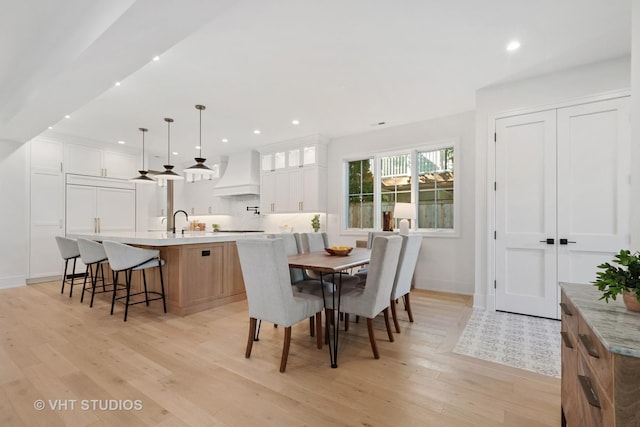 dining space with sink and light hardwood / wood-style flooring