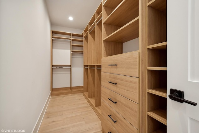 walk in closet with light hardwood / wood-style floors