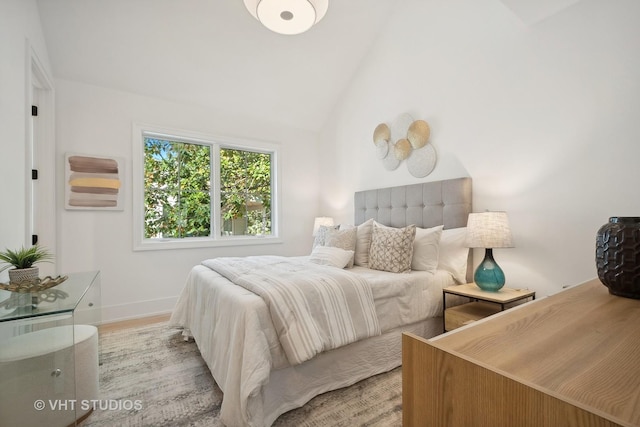 bedroom featuring lofted ceiling and light wood-type flooring