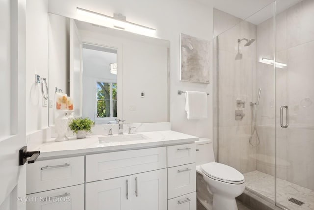 bathroom with vanity, an enclosed shower, and toilet