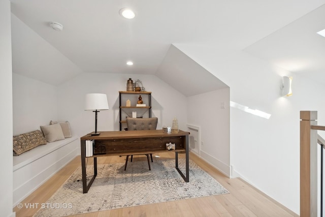 office with light hardwood / wood-style floors and vaulted ceiling