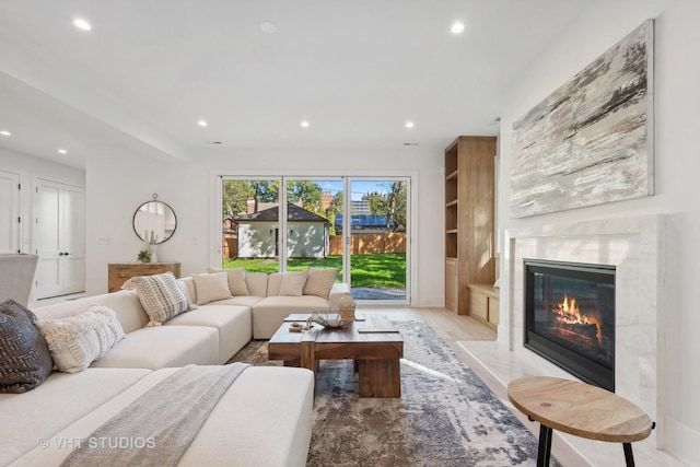 living room featuring a high end fireplace and light hardwood / wood-style flooring