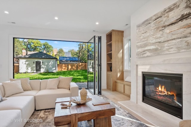 living room featuring built in shelves and a premium fireplace