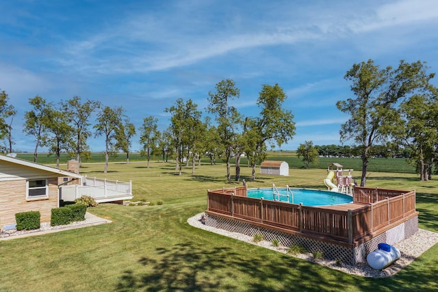 view of swimming pool with a lawn and a wooden deck