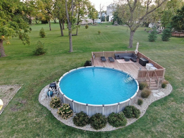 view of pool with a deck and a lawn