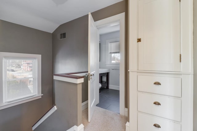 interior space featuring lofted ceiling and light colored carpet