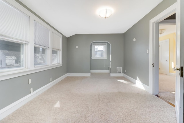 empty room featuring lofted ceiling and light colored carpet