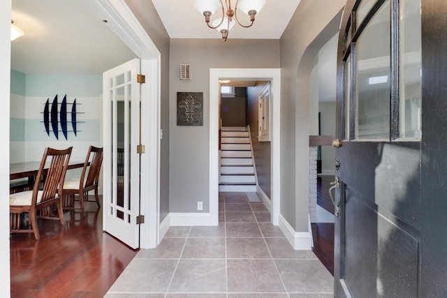 entrance foyer with hardwood / wood-style floors and an inviting chandelier