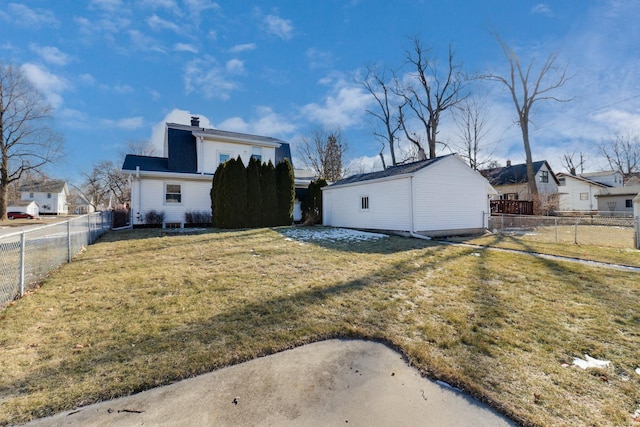 back of property featuring a yard and an outdoor structure