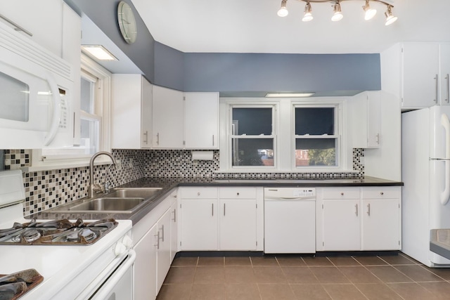 kitchen featuring tasteful backsplash, white cabinetry, sink, dark tile patterned flooring, and white appliances