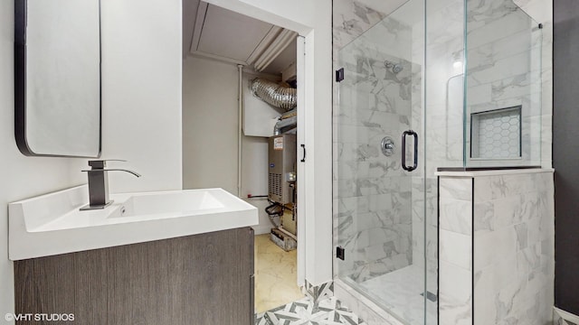 bathroom with water heater, a shower with door, and vanity