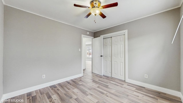 unfurnished bedroom featuring ceiling fan, a closet, light hardwood / wood-style floors, and ornamental molding