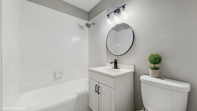 full bathroom featuring tiled shower / bath, vanity, and toilet